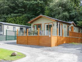 A log cabin with a deck and furniture at 19 Pony Meadow White Cross Bay near Troutbeck Bridge