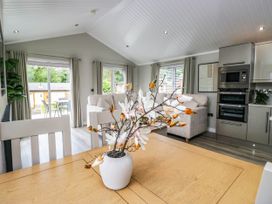 A living room with a dining table and a sofa at 19 Pony Meadow White Cross Bay near Troutbeck Bridge