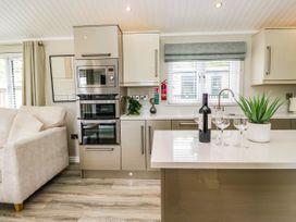 A kitchen with a countertop, oven, and seating area at 19 Pony Meadow near White Cross Bay