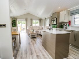 A living room with a sofa and dining table at 19 Pony Meadow in White Cross Bay near Troutbeck Bridge