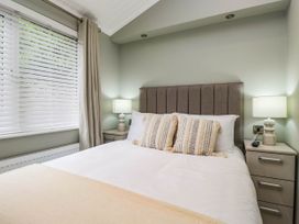 A bedroom with a bed and bedside table at 19 Pony Meadow White Cross Bay near Troutbeck Bridge