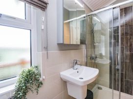 A bathroom with a shower and sink at 19 Pony Meadow White Cross Bay near Troutbeck Bridge
