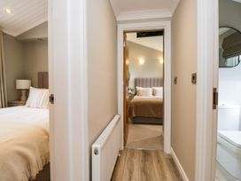 A hallway with doors to bedrooms and bathroom at 19 Pony Meadow White Cross Bay near Troutbeck Bridge