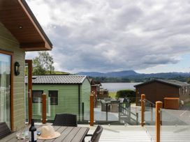 A view of a lake and cabins from a deck at 19 Pony Meadow White Cross Bay near Troutbeck Bridge