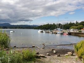 A lakeside view with boats moored at the pier at 19 Pony Meadow White Cross Bay near Troutbeck Bridge