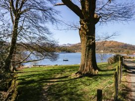 A view of a lake with boats and trees at 19 Pony Meadow White Cross Bay near Troutbeck Bridge