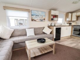 A living room with a sofa and kitchen area at B54