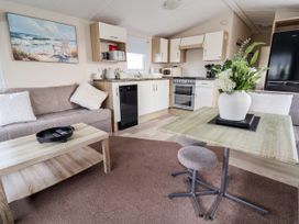 A living room with a sofa, coffee table, and kitchen appliances at B54