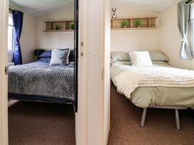 A bedroom with two beds and shelves at B54