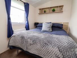 A bedroom with a bed and shelf at B54 in 
