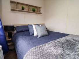 A bedroom with a bed and shelf at B54 
