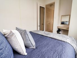 A bedroom featuring a bed with pillows, a mirror, and a door at B54 