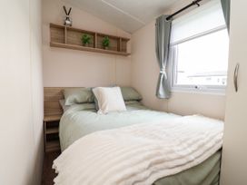 A bedroom with a bed, shelf, and window at B54