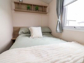 A bedroom with a bed and shelf at B54