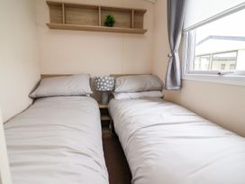 A bedroom with two beds and a lamp at B54