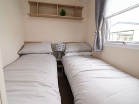 A bedroom with two beds and a lamp on the shelf at B54