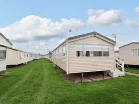 Mobile homes lined along a grassy pathway in an outdoor area at B54