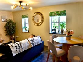 A living room with a table and chairs at Muddy Boots – La Petite Mews Kirby Stephen