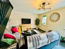 A living room with a sofa and television at Muddy Boots – La Petite Mews in Kirby Stephen