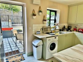 A kitchen with a washing machine and kitchen sink at Muddy Boots – La Petite Mews in Kirby Stephen