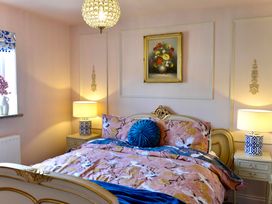 A bedroom with a bed and lamps at Muddy Boots – La Petite Mews in Kirby Stephen
