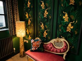 A sitting room with a sofa and lamp at Muddy Boots – La Petite Mews, Kirby Stephen