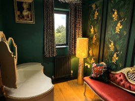A sitting room with a table and a chair at Muddy Boots – La Petite Mews in Kirby Stephen