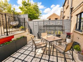 A garden with a table and chairs at Muddy Boots – La Petite Mews in Kirby Stephen