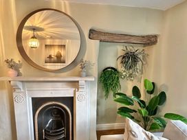 A living room with a fireplace and plants at Muddy Boots – Arcade Royale, Kirby Stephen