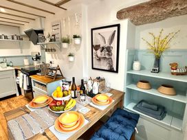 A kitchen with a dining table set for a meal at Muddy Boots – Arcade Royale in Kirby Stephen