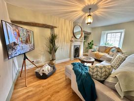 A living room with a television and sofa at Muddy Boots – Arcade Royale in Kirby Stephen