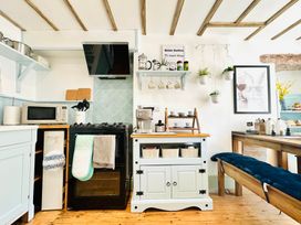 A kitchen with appliances and shelving at Muddy Boots – Arcade Royale Kirby Stephen