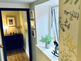 A hallway with a lamp, flower arrangement and drawers at Muddy Boots – Arcade Royale in Kirby Stephen