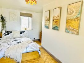 A bedroom with a bed and wall art at Muddy Boots – Arcade Royale in Kirby Stephen
