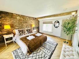 A bedroom with a bed and nightstand at Muddy Boots – Arcade Royale in Kirby Stephen