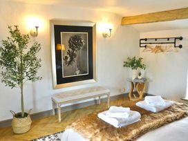 A bedroom with a bench, plant, and towels at Muddy Boots – Arcade Royale, Kirby Stephen