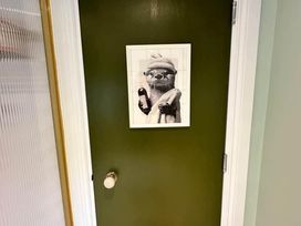 A green door with a framed picture in a hallway at Muddy Boots – Arcade Royale, Kirby Stephen