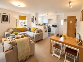 A living room with a sofa and dining table at Muddy Boots – Scarpa, Kirkby Stephen