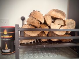 A wood rack with firewood and a fire starter canister at Muddy Boots – Scarpa in Kirkby Stephen