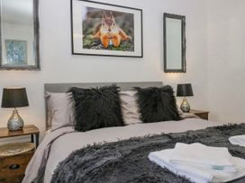A bedroom with a bed and decorative pillows at Muddy Boots – Scarpa in Kirkby Stephen