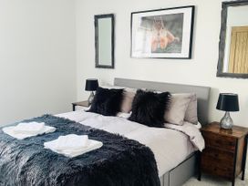 A bedroom with a bed and nightstands at Muddy Boots – Scarpa in Kirkby Stephen