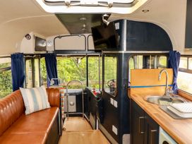 A living room with a sofa and sink at Honey Bee Bus in Menheniot