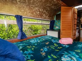 A bedroom with a bed and window at Honey Bee Bus in Menheniot