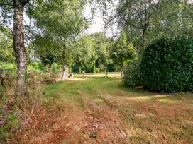 A garden with trees and grass at Honey Bee Bus in Menheniot