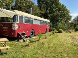 A red bus in a garden at Honey Bus in Menheniot