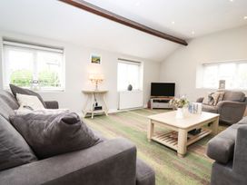 A living room with a sofa and coffee table at Peewit Barn in Moreton-in-Marsh
