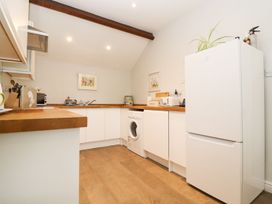 A kitchen with white cabinets and appliances at Peewit Barn in Moreton-in-Marsh
