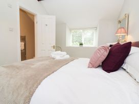 A bedroom with a bed and window at Peewit Barn in Moreton-in-Marsh