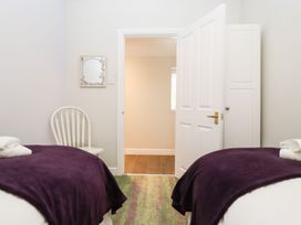 A bedroom with two beds and a chair at Peewit Barn in Moreton-in-Marsh