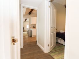 A hallway with doors leading to a kitchen and bedroom at Peewit Barn in Moreton-in-Marsh
